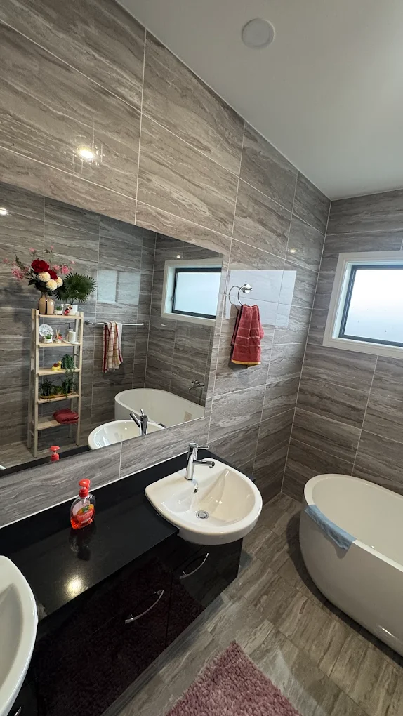 Modern marble-tiled bathroom with freestanding tub after professional clean