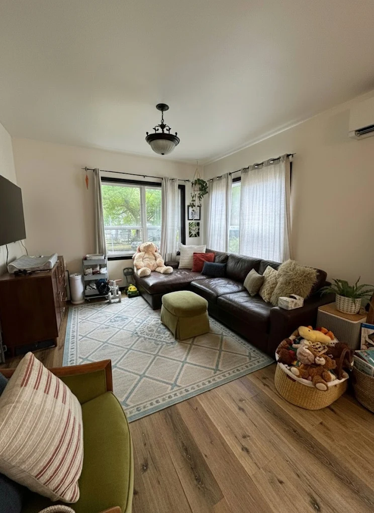 Lived-in lounge room with leather lounge and rug freshened after a clean
