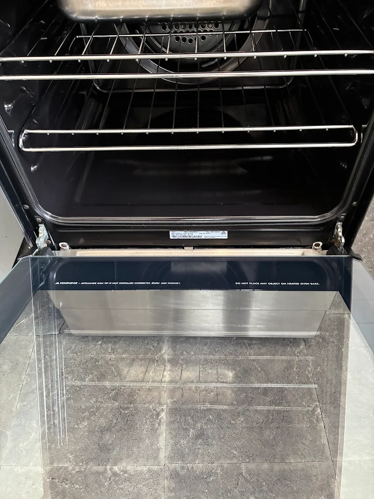 Inside of oven cavity scrubbed clean with door open showing spotless interior