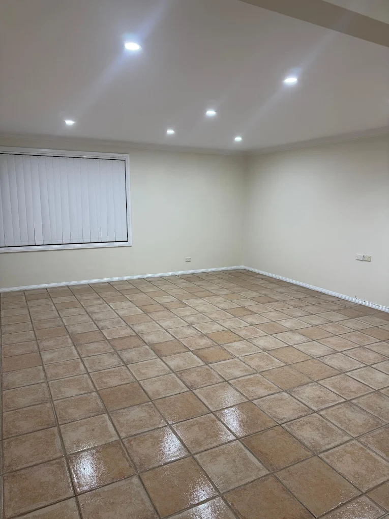 Empty terracotta-tiled rumpus room mopped and polished for end of lease vacate clean