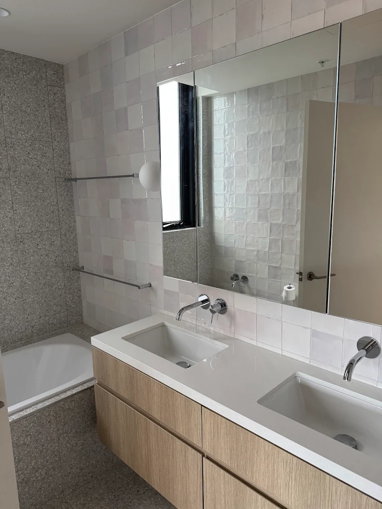 Modern double-vanity bathroom with zellige tiles cleaned for handover