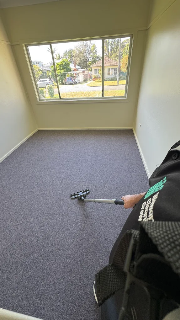 Illawarra Cleaning Crew team member vacuuming carpet in an empty Wollongong bedroom